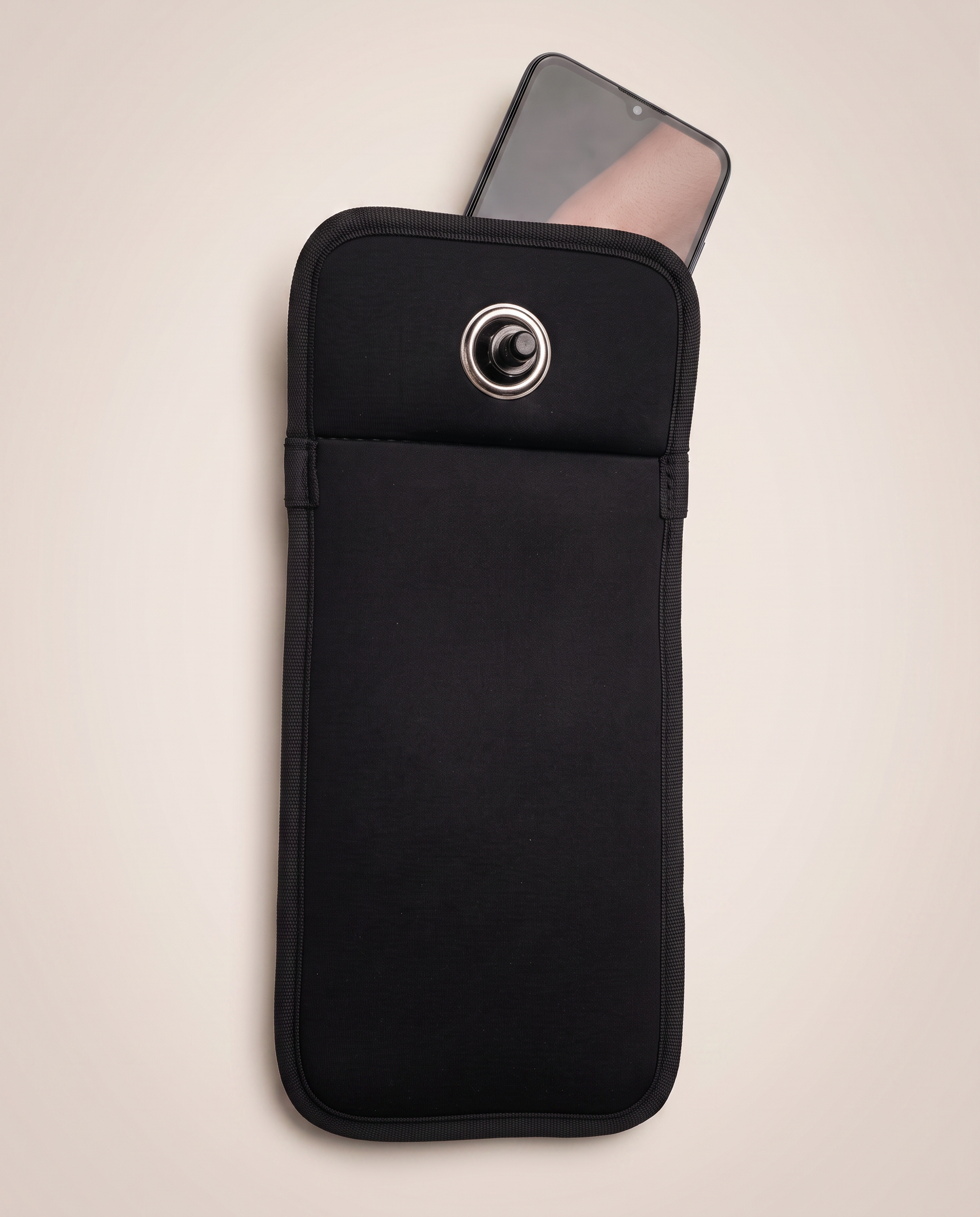 A phone sliding into the matte black TOVI pouch.